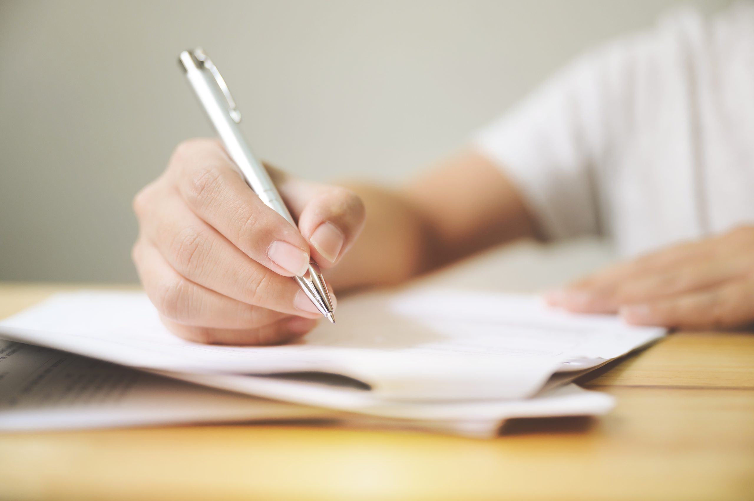 Hand of a man signing a document
