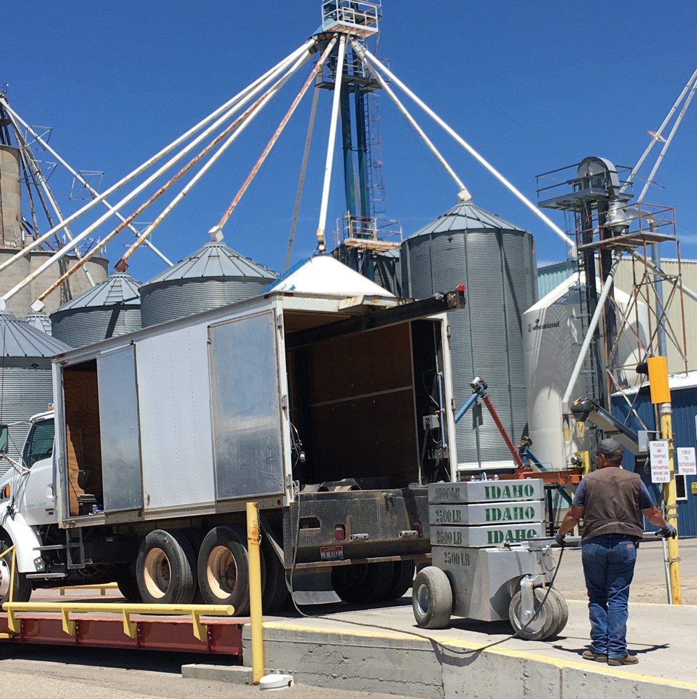 Employee removing calibrated weights out of a scale truck to inspect and test facility scales