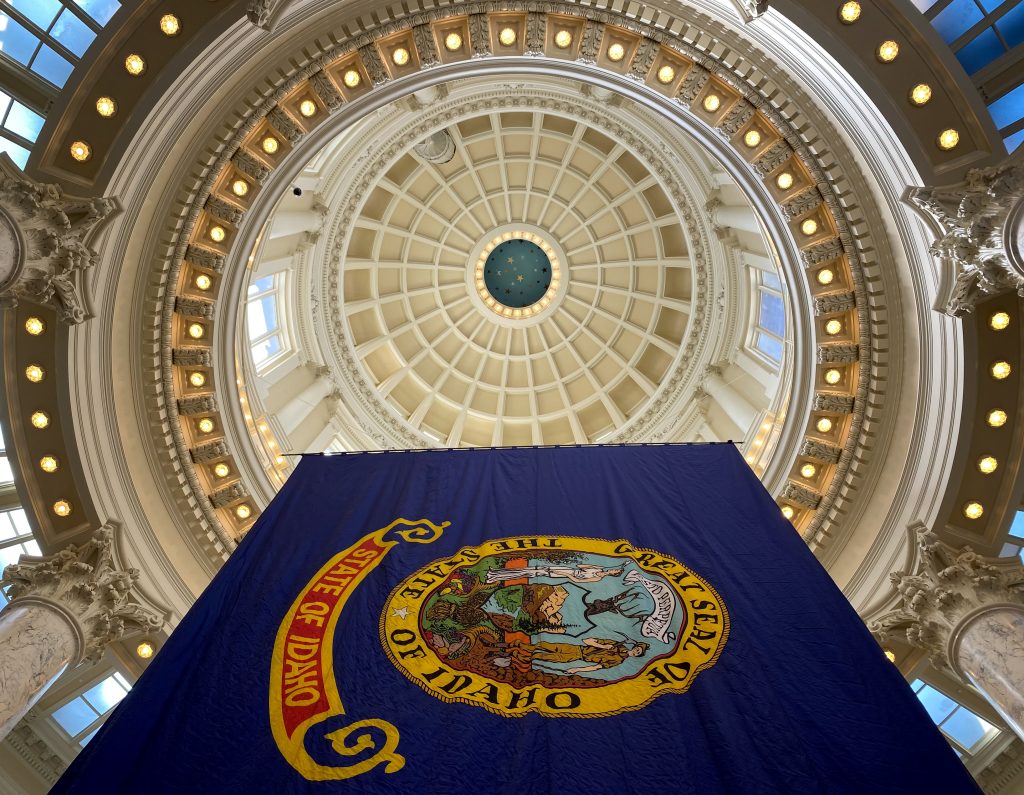 Image of the Idaho state flag hanging in the rotunda of the state capitol building.