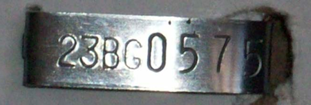 Image showing an 8 character silver metal identification tag for swine. Image copyright USDA