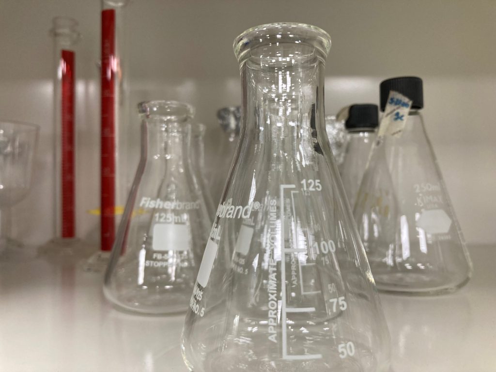 Laboratory glassware including flasks and graduated cylinders.